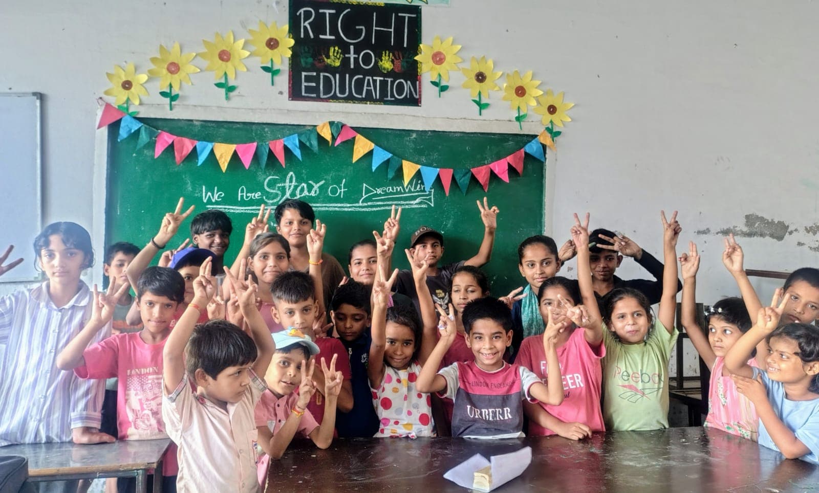 Students in a classroom with 'Right to Education' banner celebrating their learning